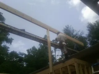 Carpenter setting a ridge beam over a new addition frame in Duncan Falls