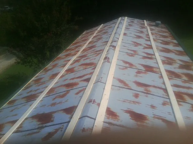 Rusted metal roof panels with new wood purlins before replacement — Storm Damage Roof Repair in Duncan Falls by Roofing Brothers