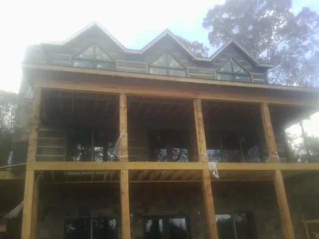 Dormers and porch framing on a large log home under construction — Roof Coating work by our crew in Duncan Falls