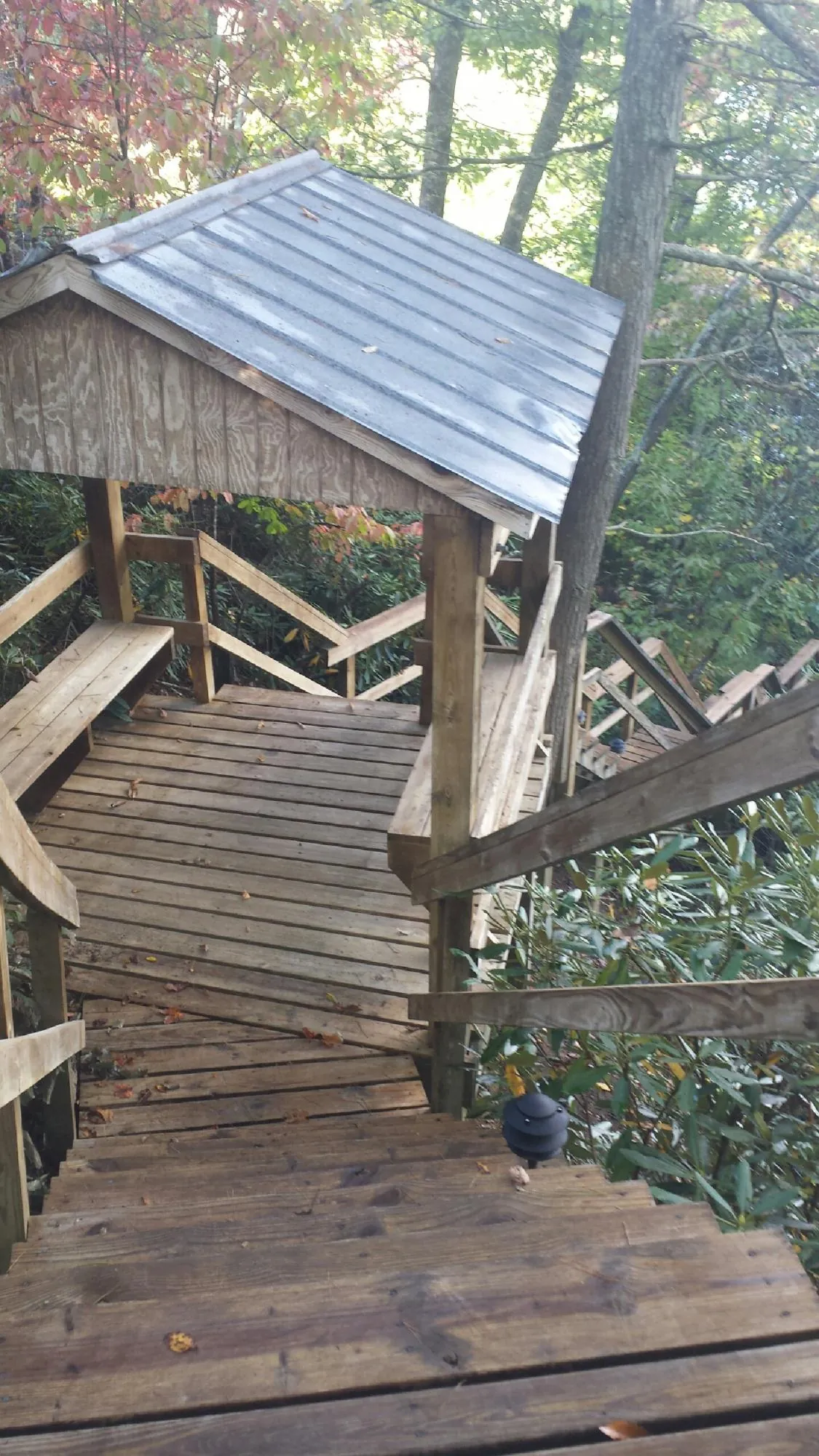 Metal roofed shelter over wooden steps on a wooded walkway — Skylight Repair & Installation work by our crew in Duncan Falls