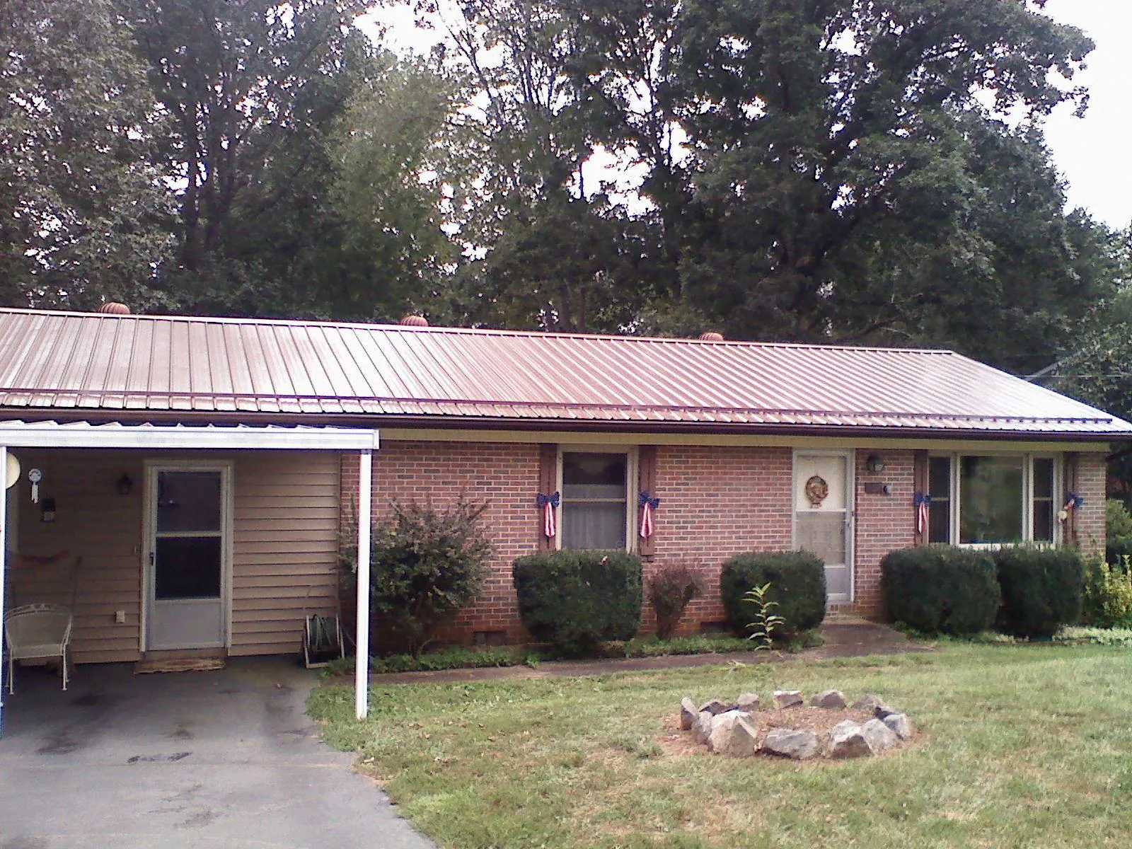 Bronze metal roof and carport on a brick ranch home — Roof Repair work by our crew in Duncan Falls