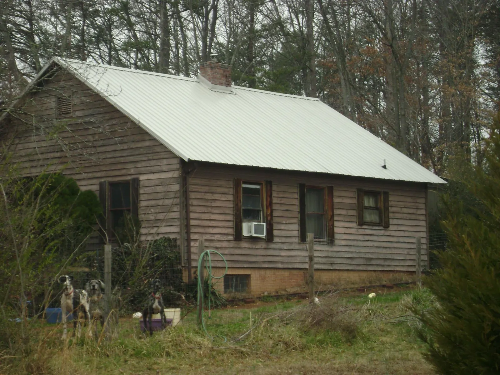 White metal roof on an old wood sided farmhouse, from a Metal Roof Installation job in Duncan Falls